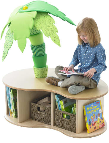 Ein kleines Kind sitzt im Schneidersitz auf einer hölzernen Leseecke in Form einer Insel mit einer weichen Stoffpalme. In der Ecke befinden sich Regale mit Büchern und geflochtenen Körben. Das Kind schaut auf ein aufgeschlagenes Buch.