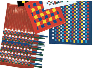 Mehrere Stücke Baupapier mit Streifen, die in einem Schachbrettmuster aus verschiedenen Farben wie Rot, Gelb, Blau und Grün auf weißem Hintergrund verwoben sind.