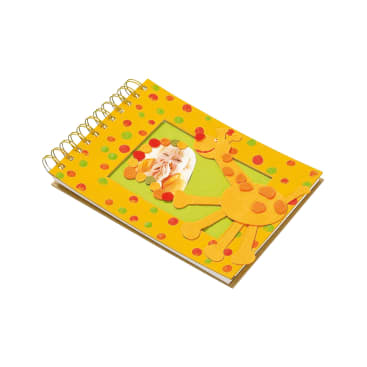 Ein spiralgebundenes Notizbuch mit gelbem Einband, der mit bunten Punkten und einer Giraffenform aus Filz verziert ist, mit einem kleinen rechteckigen Foto auf der Vorderseite.