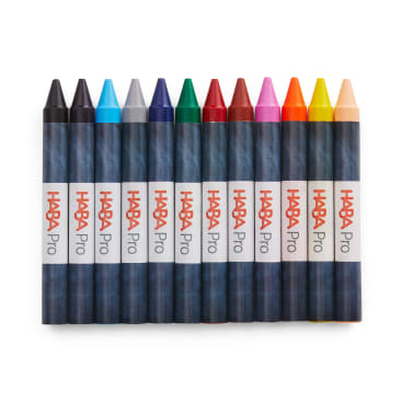 Zwölf HABA Pro Buntstifte in einer Reihe, jeder in einer anderen Farbe, auf einem weißen Hintergrund. Die Buntstifte haben dunkelblaue Verpackungen mit der Aufschrift HABA Pro in roter und grauer Schrift.