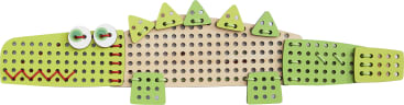 Ein Krokodilspielzeug aus Holz mit grün bemalten Teilen, dreieckigen Stacheln auf dem Rücken, zwei weißen runden Augen und roten Schnüren, die durch Löcher im Gesicht und am Körper gefädelt sind.