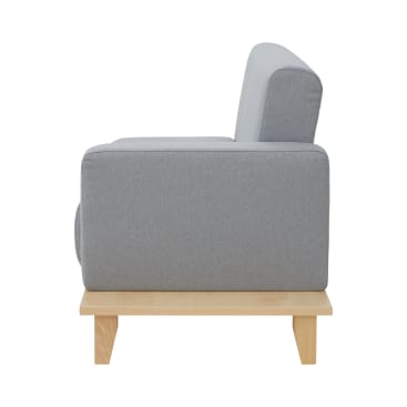 Ein grau gepolsterter Sessel mit kastenförmigem Design und Holzbeinen, von der Seite gesehen vor einem weißen Hintergrund.