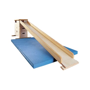 Eine Holzrutsche, die an einem Kletterkasten befestigt ist, liegt auf zwei blauen Turnmatten auf weißem Hintergrund.