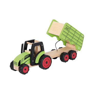 Ein grüner und schwarzer Spielzeugtraktor aus Holz mit roten Rädern ist an einem Anhänger mit einer kippbaren grünen Ladefläche befestigt. Der Anhänger ist angehoben und zeigt eine Kippstellung. Der Hintergrund ist einfarbig weiß.