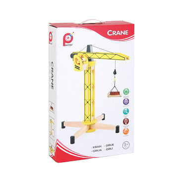 Eine Schachtel mit einem gelben Spielzeugkran auf der Vorderseite. Der Kran ist aus Holz und hat einen Haken, der eine kleine Last hält. Auf der Schachtel befinden sich ein Branding und Symbole, und es heißt, dass das Spielzeug für Kinder ab 3 Jahren geeignet ist.