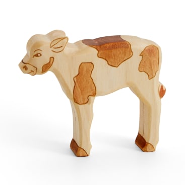 Eine Spielzeugkuh aus Holz mit hell- und dunkelbraunen Flecken steht auf einem weißen Hintergrund. Die Figur weist einfache geschnitzte Details für Gesicht und Körper auf.