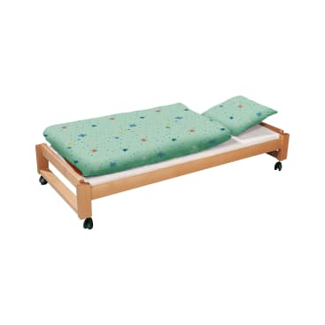 Ein hölzerner Bettrahmen mit Rädern, der mit einem grünen Kissen- und Decken-Set mit bunten Sternenmustern verziert ist. Das Bett ist vor einem schlichten weißen Hintergrund abgebildet.