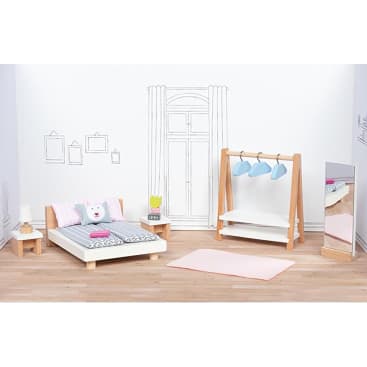 Ein Miniatur-Schlafzimmer mit einem Bett, Nachttischen, einer Lampe, einem Teppich, einem Standspiegel und einem hölzernen Kleiderständer mit blauen Bügeln; Wandkunst und Fenster sind auf dem weißen Hintergrund gezeichnet.