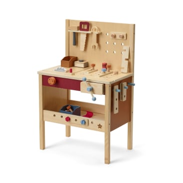 Eine hölzerne Werkbank für Kinder mit Spielzeugwerkzeugen, darunter eine Säge, ein Schraubenschlüssel, ein Schraubenzieher und ein Hammer. Das Set hat Löcher zur Werkzeugaufbewahrung, ein Regal darunter und verschiedene Holzteile, die an der Oberfläche befestigt sind.