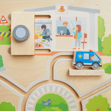 Ein Holzspielzeugpuzzle mit einem verschiebbaren Polizeiwagen und einem Block, der einem Tresor ähnelt, vor dem Hintergrund einer illustrierten Polizeistation mit Zeichentrickfiguren im Inneren. Darunter ist eine kleine Parklandschaft mit einem Vogel zu sehen.