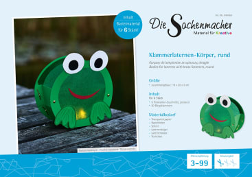 Produktverpackung für ein grünes, rundes, froschförmiges Laternen-Bastelset. Inhalt und benötigte Materialien sind in deutscher Sprache angegeben; geeignet für 3 - 99 Jahre. Die Laterne hat große Augen und ein lächelndes Gesicht.