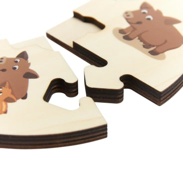 Nahaufnahme von zwei ineinander greifenden Holzpuzzleteilen mit Abbildungen von braunen Cartoon-Schweinen auf weißem Hintergrund. Die Teile sind teilweise miteinander verbunden und haben eine glatte, natürliche Holzoberfläche.