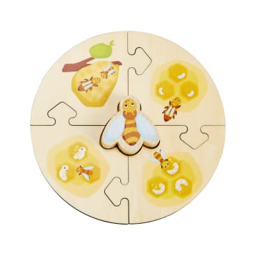 Ein rundes Holzpuzzle mit fünf Teilen, die Abbildungen von Bienen, Honigwaben und einem grünen Apfel zeigen. Das mittlere Teil hat die Form einer Biene und die umliegenden Teile stellen verschiedene Bienen- und Wabenszenen dar.