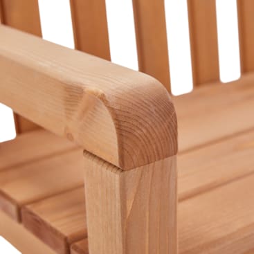 Nahaufnahme einer Armlehne eines Holzstuhls, die glatte, abgerundete Kanten und eine sichtbare Holzmaserung zeigt. Der Stuhl hat vertikale Latten für die Rückenlehne und den Sitz.