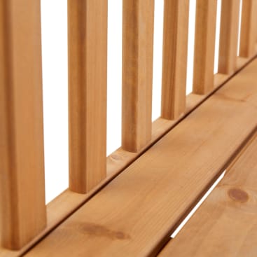 Nahaufnahme von vertikalen Holzlatten, die an einem Holzsockel befestigt sind, wahrscheinlich Teil eines Möbelstücks wie einer Bank oder eines Stuhls, mit einer natürlichen Holzoberfläche.