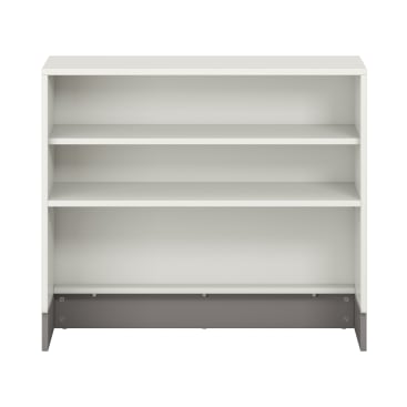 Ein weißes Bücherregal mit drei Regalen, einer massiven Rückwand und einem kontrastierenden grauen Sockel, das leer vor einem unifarbenen Hintergrund gezeigt wird.