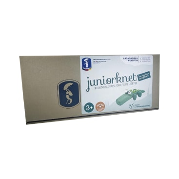 Eine braune rechteckige Schachtel mit einem Etikett mit der Aufschrift juniorknet und der Abbildung eines grünen Krokodilspielzeugs. Die Verpackung enthält Piktogramme und Text in deutscher Sprache und gibt an, dass sie für Kinder ab 2 Jahren geeignet ist.
