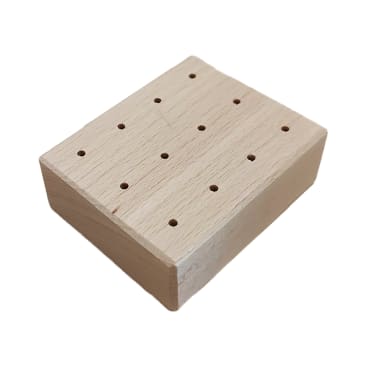 Ein Holzblock mit mehreren Löchern hält vier Ahlen mit Holzgriffen, von denen drei aufrecht stehen und eine waagerecht liegt. Der Hintergrund ist einfarbig weiß.