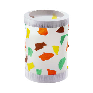 Ein zylindrischer Behälter mit weißem Korpus, verziert mit zerrissenen bunten Papierstücken in Gelb, Grün, Orange und Braun und grauem oberen und unteren Rand.