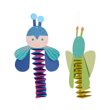 Zwei bunte Papierbasteleien, die Insekten ähneln, hängen vor einem weißen Hintergrund. Eines ist blau und rosa mit Fühlern und Flügeln, das andere ist grün und gelb mit großen Flügeln und geraden Fühlern.