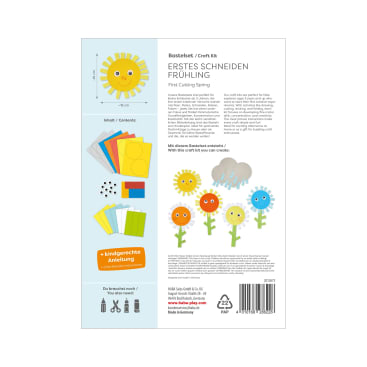 Eine Bastelpackung mit der Aufschrift Erstes Schneiden Frühling zeigt den Inhalt, darunter farbiges Papier, Klebstoff und Glupschaugen. Illustrierte Blumen und eine Sonne sind neben der Anleitung in Deutsch und Englisch abgebildet.