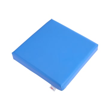 Ein quadratisches blaues Schaumstoffkissen mit glatter Oberfläche und leicht abgerundeten Kanten, fotografiert vor einem weißen Hintergrund. Auf einer Seite ist ein kleines Stoffetikett sichtbar.