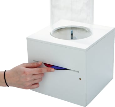 Eine Hand schiebt einen roten und blauen Schieber auf der Vorderseite eines weißen Kastens mit einer durchsichtigen zylindrischen Kammer oben, in der ein blauer Marker aufrecht steht.