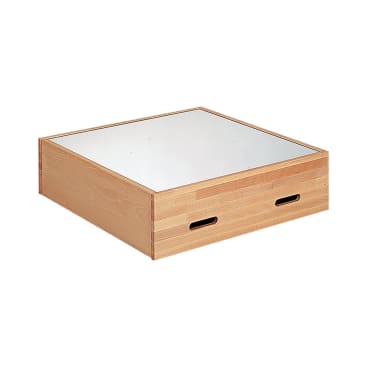 Eine quadratische Holzkiste mit zwei ovalen, ausgeschnittenen Griffen an der Seite und einer reflektierenden Spiegelfläche an der Oberseite, isoliert auf weißem Hintergrund.