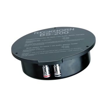 Ein schwarzes, rundes Reckhorn BS-200 Körperschüttelgerät mit beschrifteter Oberseite und zwei metallischen Anschlüssen an der Unterseite, entwickelt für Home- und Car-Audio, Spiele und Gesundheitsanwendungen.