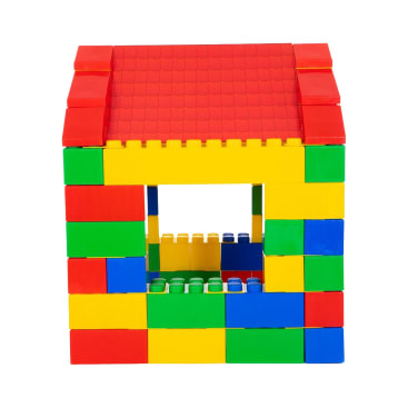 Ein kleines Haus aus bunten, ineinander greifenden Plastiksteinen mit rotem Dach, einer Fensteröffnung an der Vorderseite und Wänden aus gelben, grünen, blauen und roten Steinen.