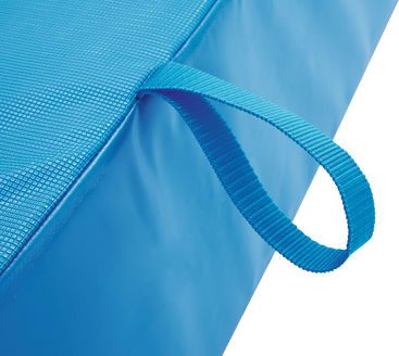 Nahaufnahme einer blauen Schaumstoffmatte mit strukturierter Oberfläche und einer blauen Tragegriffschlaufe aus Stoff an einer Kante.