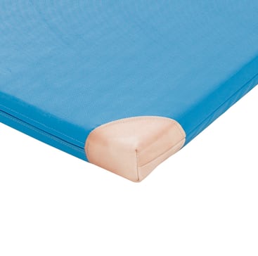 Eine blaue, rechteckige Matte mit einer strukturierten Oberfläche und einer rosa Schutzhülle an einer Ecke, abgebildet vor einem weißen Hintergrund.