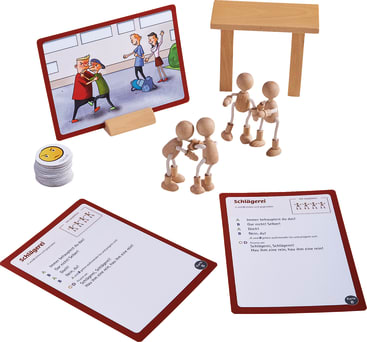 Eine Tischaufstellung zeigt Holzfiguren, die in der Nähe eines Tisches aufgestellt sind, eine Karte mit einer Cartoon-Illustration eines Schulkampfes, zwei schriftliche Karten mit der Aufschrift Schlägerei und einen Stapel runder Spielsteine mit einem neutralen Gesichtssymbol.