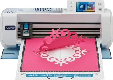 Die elektronische Schneidemaschine Brother ScanNCut schneidet ein rosa Blatt Papier in ein dekoratives Blumenmuster. Der Bildschirm und die Steuertasten der Maschine sind oben rechts zu sehen.