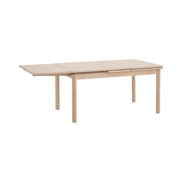 Ein rechteckiger Esstisch aus hellem Holz mit vier geraden Beinen und einer verlängerten Platte an einem Ende, vor einem schlichten weißen Hintergrund.
