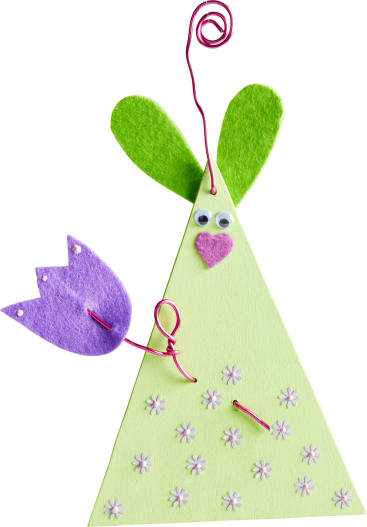 Eine dreieckige grüne Bastelfigur mit grünen Filzohren, Kulleraugen, einer rosa Filzherznase und einem Drahtarm, der eine lila Filzblume hält. Kleine weiße Blumen verzieren den Körper. Ein rosafarbener Draht bildet einen Wirbel an der Spitze.