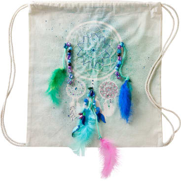 Eine Stofftasche mit Kordelzug zeigt ein aufgedrucktes Traumfänger-Motiv mit blauen und violetten Perlen und drei bunten Federn in Blau, Grün und Rosa, die an dem Kunstwerk befestigt sind. Die Tasche ist cremefarben und hat Seilgriffe.