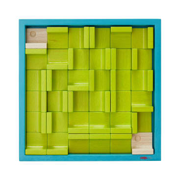 Auf einem quadratischen blauen Tablett sind ineinander greifende Holzklötze angeordnet, die größtenteils grün gestrichen sind und einige natürliche Holzteile enthalten, die ein gitterartiges, puzzleartiges Muster bilden.