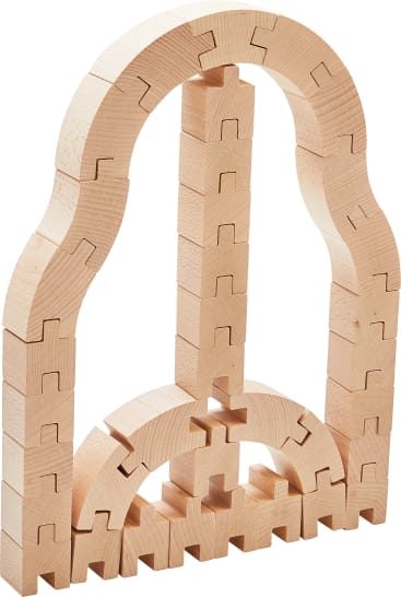Eine Struktur aus ineinandergreifenden, unfertigen Holzblöcken, die in Bögen und vertikalen Stapeln angeordnet sind und ein symmetrisches Muster bilden. Die Blöcke haben puzzleartige Kanten und variierende gebogene und gerade Formen.