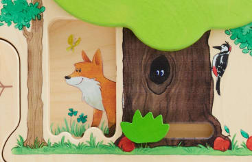 Ein hölzernes Puzzleteil, das einen Cartoon-Fuchs in einer Waldszene zeigt, einen Baum mit einer dunklen Höhle und zwei Augen, die herausschauen, einen Specht auf dem Baumstamm, grüne Blätter und zwei rote Pilze auf dem Boden.
