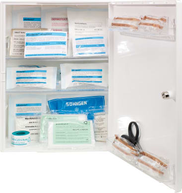 Ein offener weißer Erste-Hilfe-Schrank enthält verschiedene medizinische Hilfsmittel, darunter Verbände, Mullbinden, Klebeband, Scheren und sterile Verpackungen, die auf Regalen und in einem übersichtlichen Fach angeordnet sind.