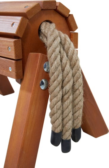 Nahaufnahme eines hölzernen Turnpferdes mit drei dicken, geflochtenen Seilen, die durch ein Loch gefädelt sind, wobei jedes Seil in einer schwarzen Gummikappe endet. Das Holz ist poliert und mit Metallbolzen befestigt.