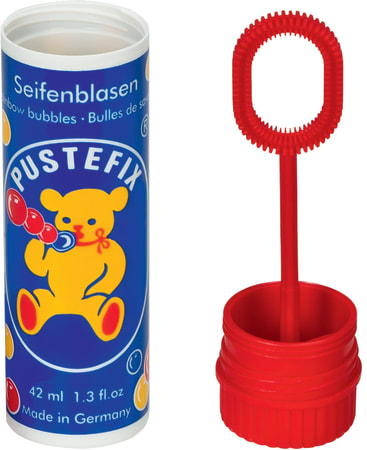 Eine Flasche Pustefix Seifenblasenlösung mit einem blauen Etikett, auf dem ein gelber Bär abgebildet ist, der Seifenblasen bläst, daneben ein roter Seifenblasenstab und eine Kappe. Die Flasche ist in Deutsch und Englisch beschriftet und enthält die Angabe 42 ml (1,3 fl oz).