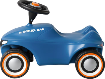 Ein blaues auffahrbares Spielzeugauto aus Kunststoff mit vier schwarz-weißen Rädern, einem orangefarbenen Knopf am Lenkrad und der Aufschrift BIG Bobby-Car an der Seite. Das Auto ist im Profil vor einem weißen Hintergrund abgebildet.