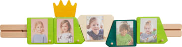 Ein Fotorahmen aus Holz mit fünf Abschnitten, die jeweils ein Kinderporträt zeigen. Der Rahmen ist in den Farben Grün, Gelb und Blau gehalten, mit einer gelben Krone über dem Mittelteil.