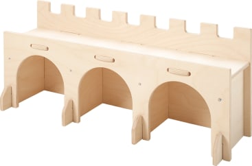 Eine helle Holzstruktur, die einer Burgmauer ähnelt, mit drei bogenförmigen Öffnungen an der Basis und einer zinnenbewehrten Oberkante. Die Struktur scheint ein Spielzeug oder eine Lagereinheit zu sein.