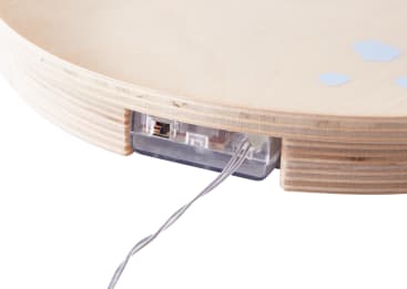 Nahaufnahme des Randes eines runden Holzobjekts mit einem eingebauten transparenten Kunststoffteil, das einen Ethernet-Anschluss und ein daran angeschlossenes Kabel enthält. Der Hintergrund ist weiß.