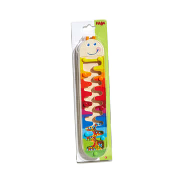 Ein verpacktes Holzspielzeug von HABA mit einem lächelnden Raupengesicht an der Spitze, mit einer Zickzackbahn und bunten Perlen, die entlang des Weges bewegt werden können. Die Verpackung hat einen grünen Hintergrund.