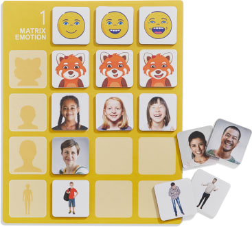 Ein gelbes Spielbrett mit der Aufschrift Matrix Emotion zeigt drei Reihen mit Karten: eine mit lächelnden Emojis, eine mit lächelnden roten Cartoon-Pandas und eine mit lächelnden Kindern. Einige Karten zeigen Erwachsene und leere Silhouetten.