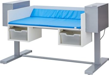 Ein medizinischer Wickeltisch mit einer blauen gepolsterten Platte, zwei transparenten Schubladen darunter und zwei vertikalen Metallelementen auf beiden Seiten, die von einem Metallrahmen getragen werden.